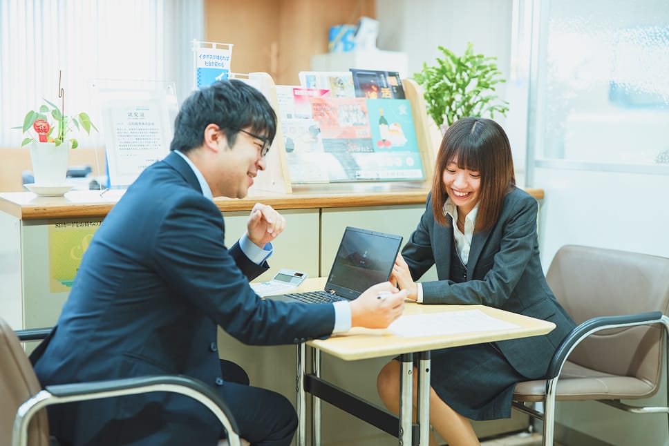 社内で打ち合わせする社員